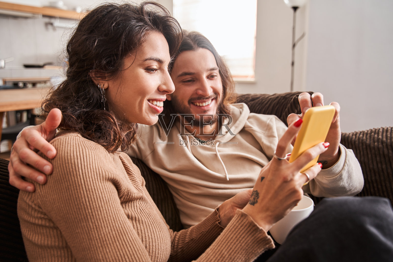 情侣一边看手机一边拥抱照片摄影图片