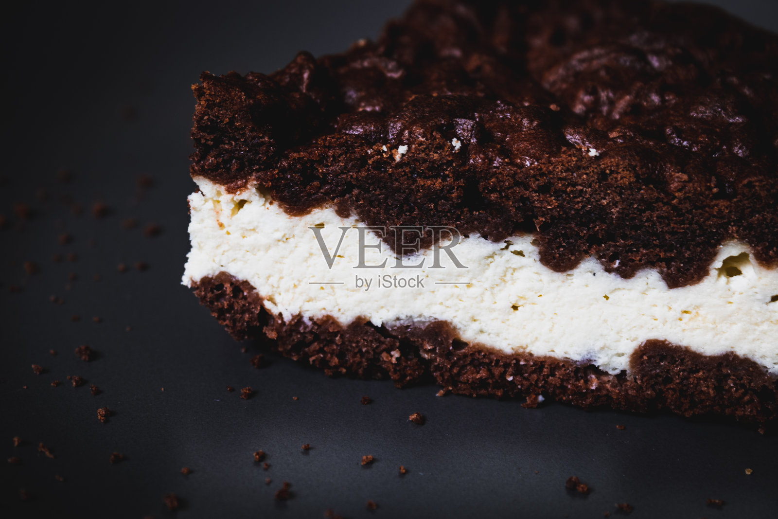 在灰色盘子上的一块美味的棕色蛋糕的特写。水平的照片照片摄影图片