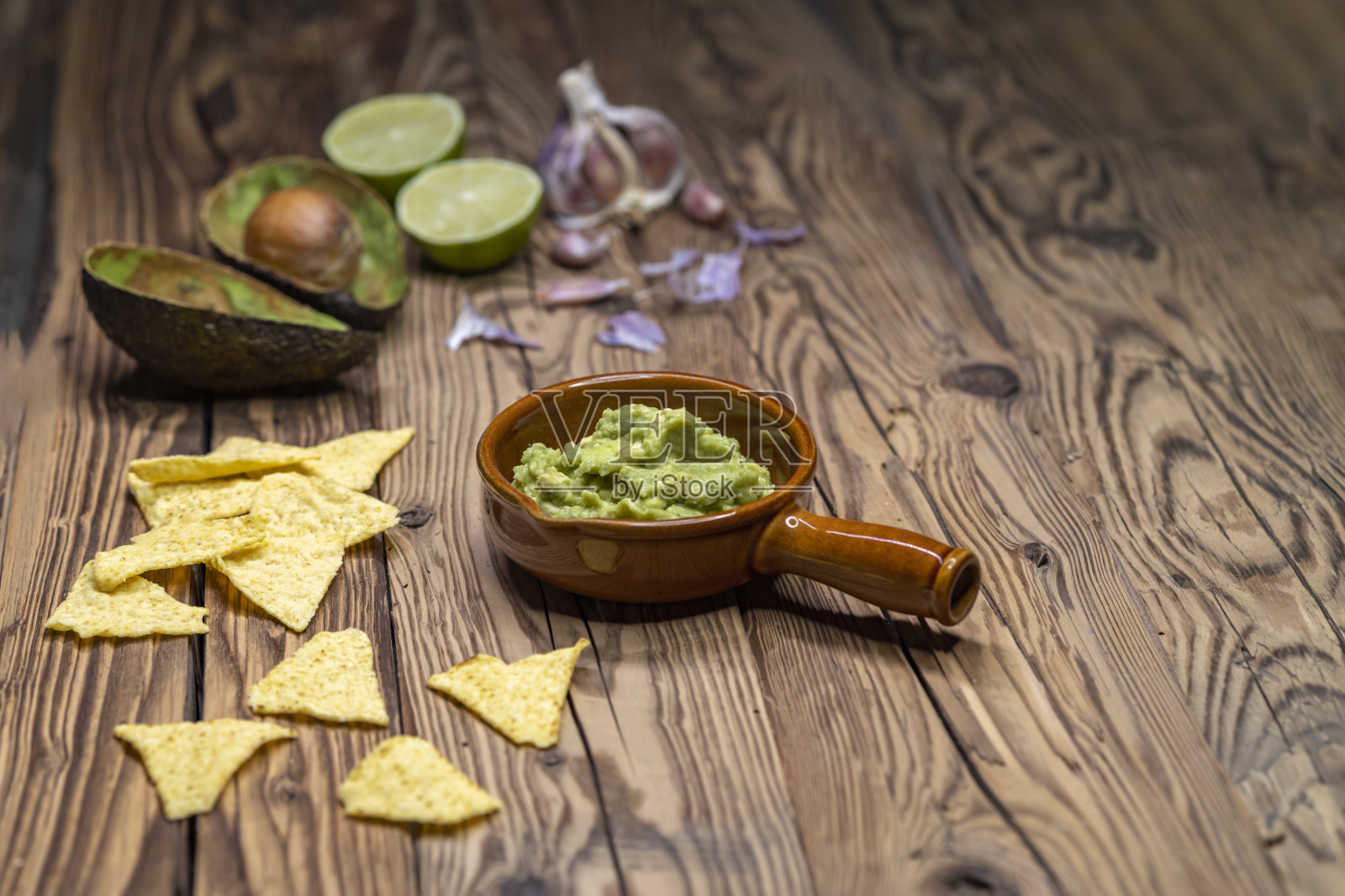 用大蒜、辣椒、辣椒、酸橙汁和玉米玉米片调味的鳄梨蘸酱照片摄影图片