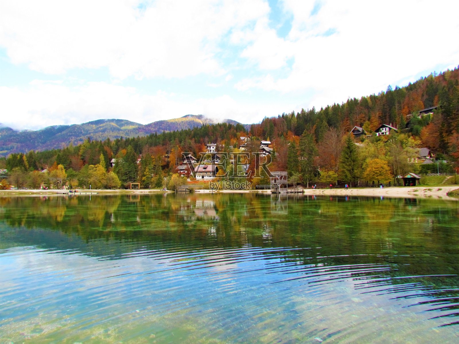 斯洛文尼亚戈伦斯卡市Kranjska Gora附近的雅斯纳湖，秋天，湖面和森林的倒影覆盖着山丘和房屋照片摄影图片