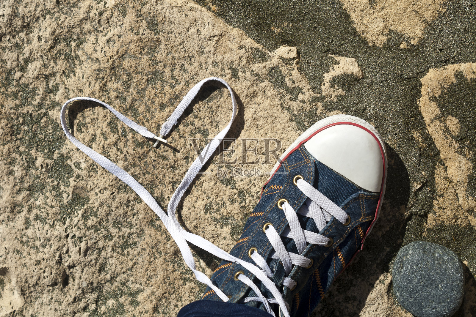 鞋带心和鞋在石头地上照片摄影图片