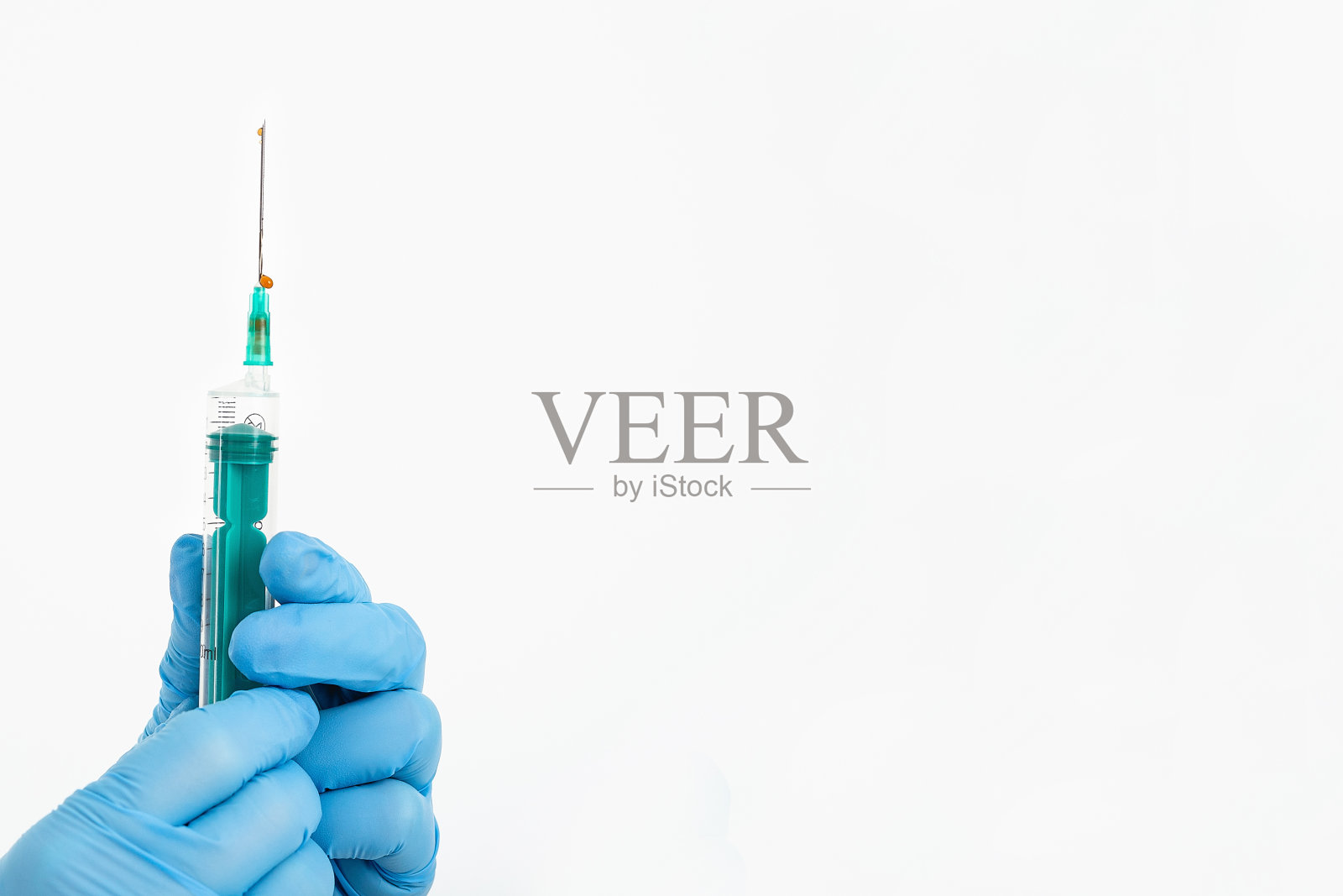 医生的手放在医用手套里，拿着一个针头注射器来预防流感病毒。心血管疾病疫苗。药物接种的概念治疗采用皮下注射，拷贝空间照片摄影图片