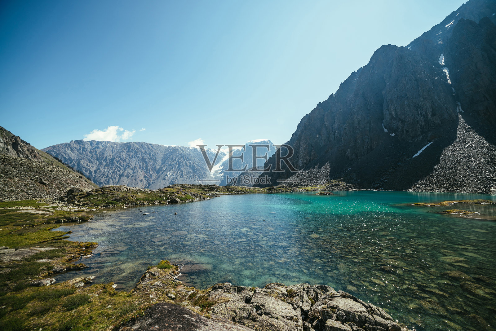 阳光明媚的令人放松的景观与天蓝色的冰川湖在阳光下。沉思的涟漪和许多反射光在绿松石清澈的水面上的山湖。美丽的风景，湖泊和冰川。照片摄影图片