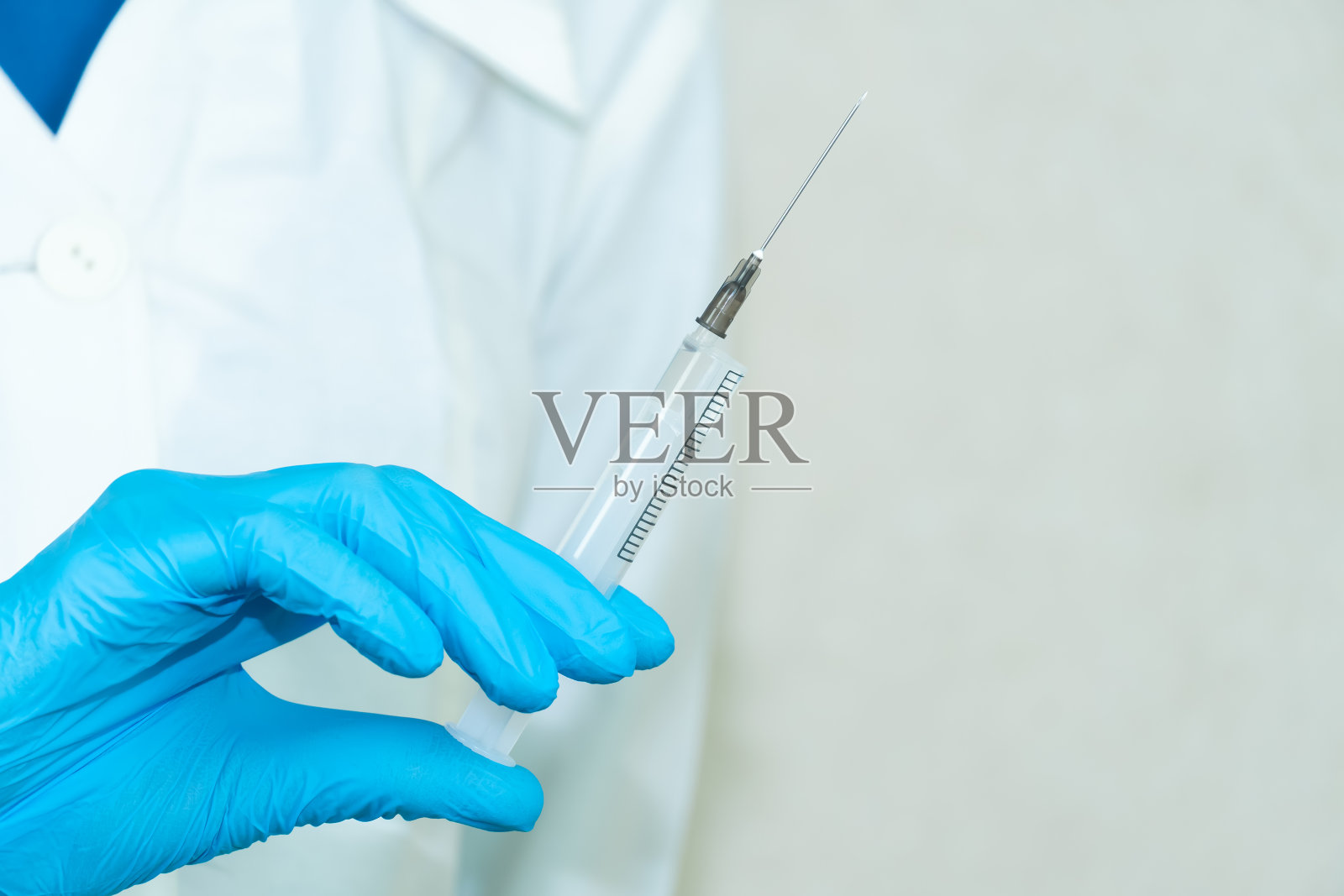 女医生手里拿着一个有针头的注射器，注射器的角度是有拷贝空间的。医学概念，疫苗接种照片摄影图片