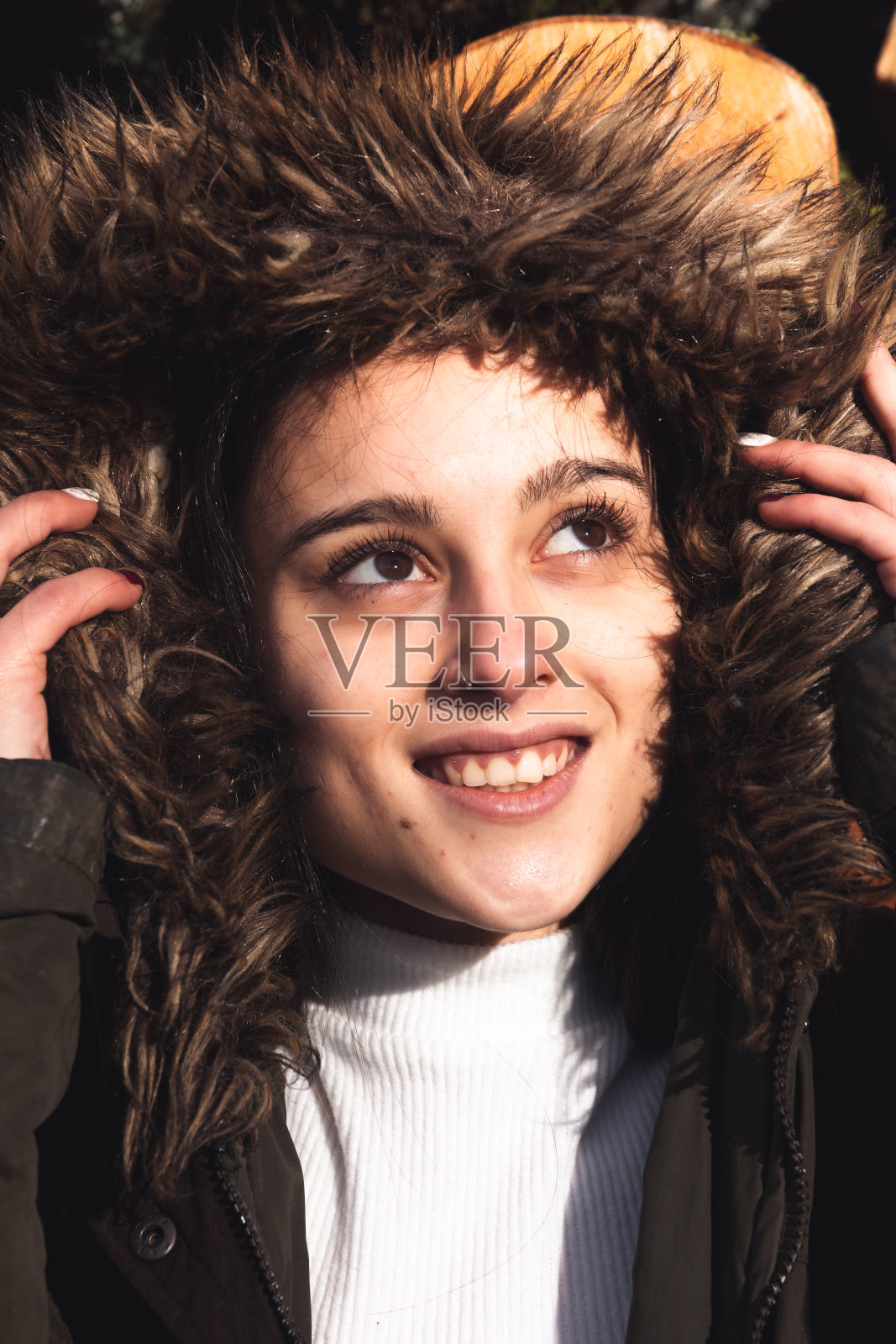 在寒冷的日子里，穿着剪短的短裤的年轻女子。照片摄影图片