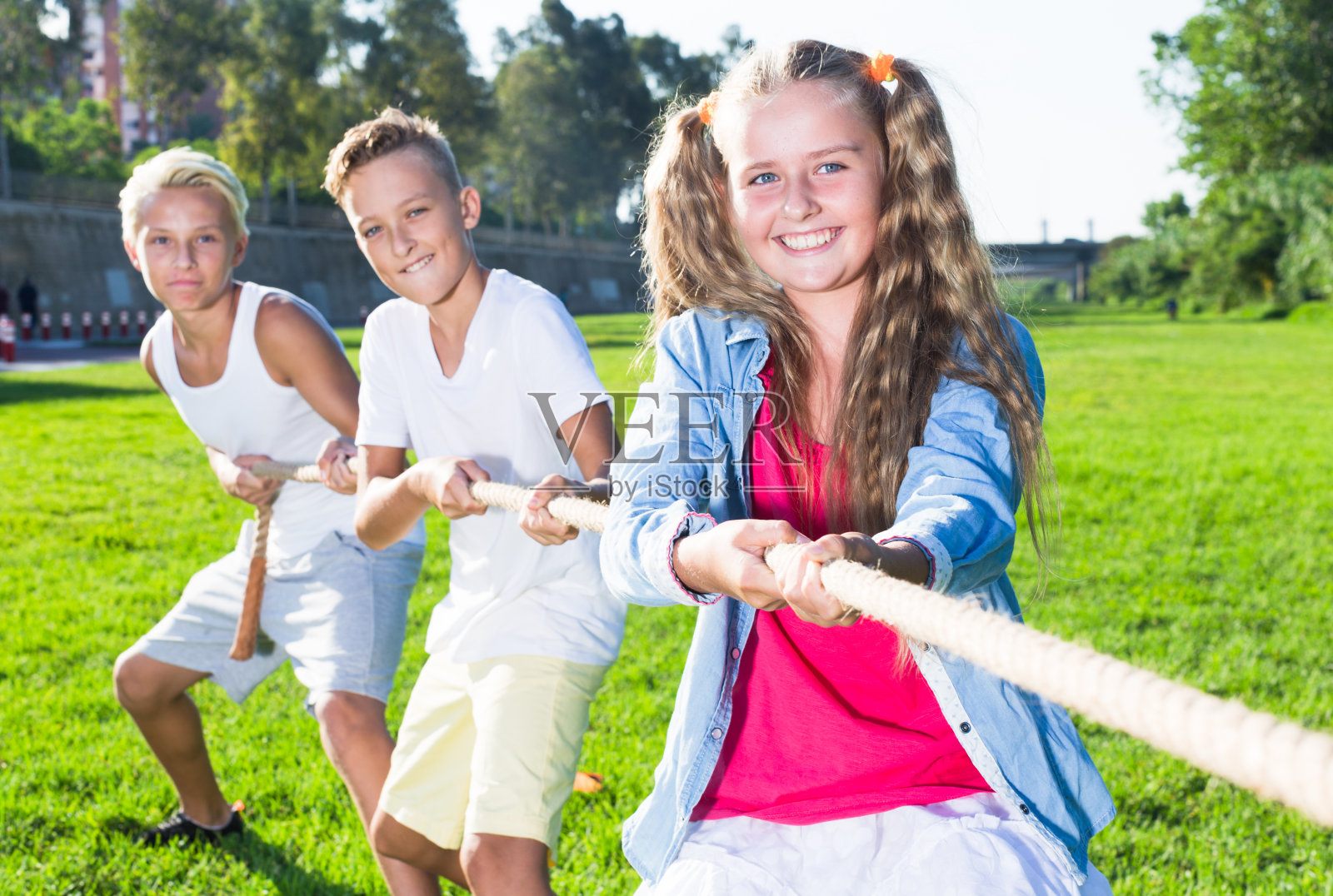 快乐的孩子们在夏季公园拔河照片摄影图片