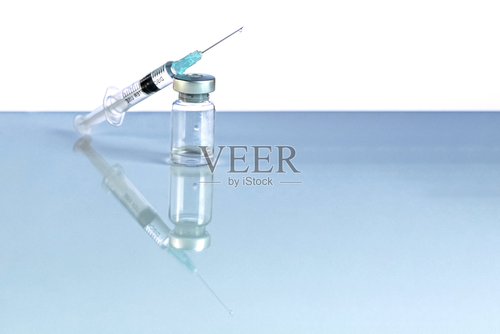 装有冠状病毒疫苗的注射器和小瓶，注射小瓶剂量在蓝色背景上。预防、医学概念、covid-19免疫接种。照片摄影图片