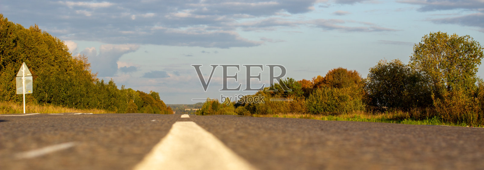 一条长长的白色条纹，像路标。田野之间的道路照片摄影图片