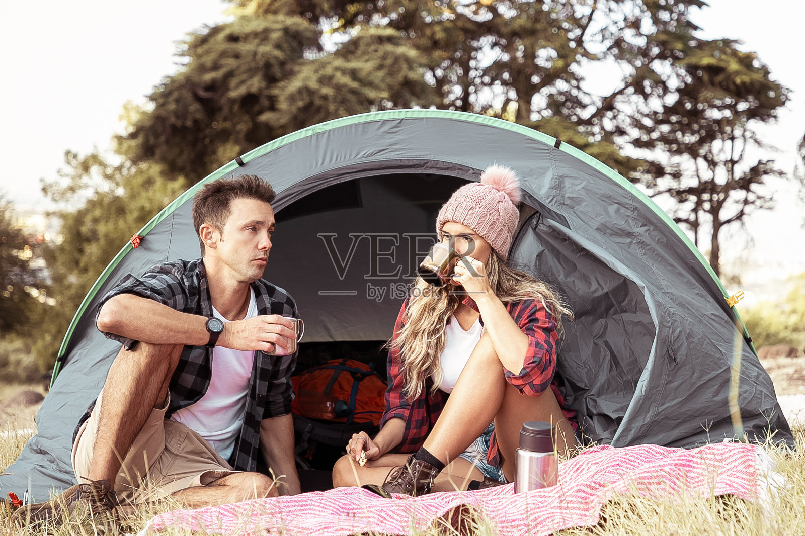 年轻夫妇一起在大自然中放松，一起喝茶照片摄影图片