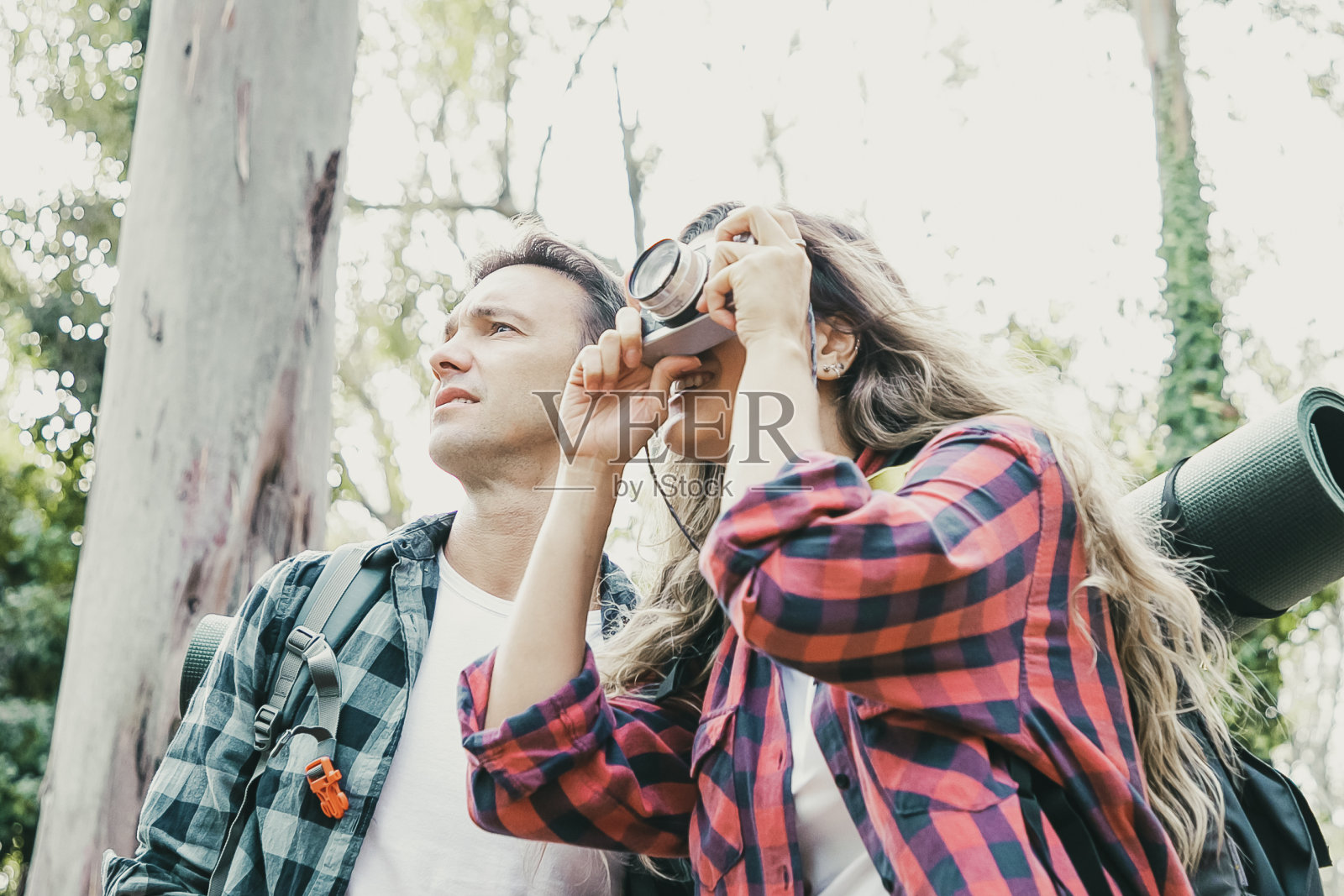 两个年轻的徒步旅行者带着相机走在山间森林的路上照片摄影图片