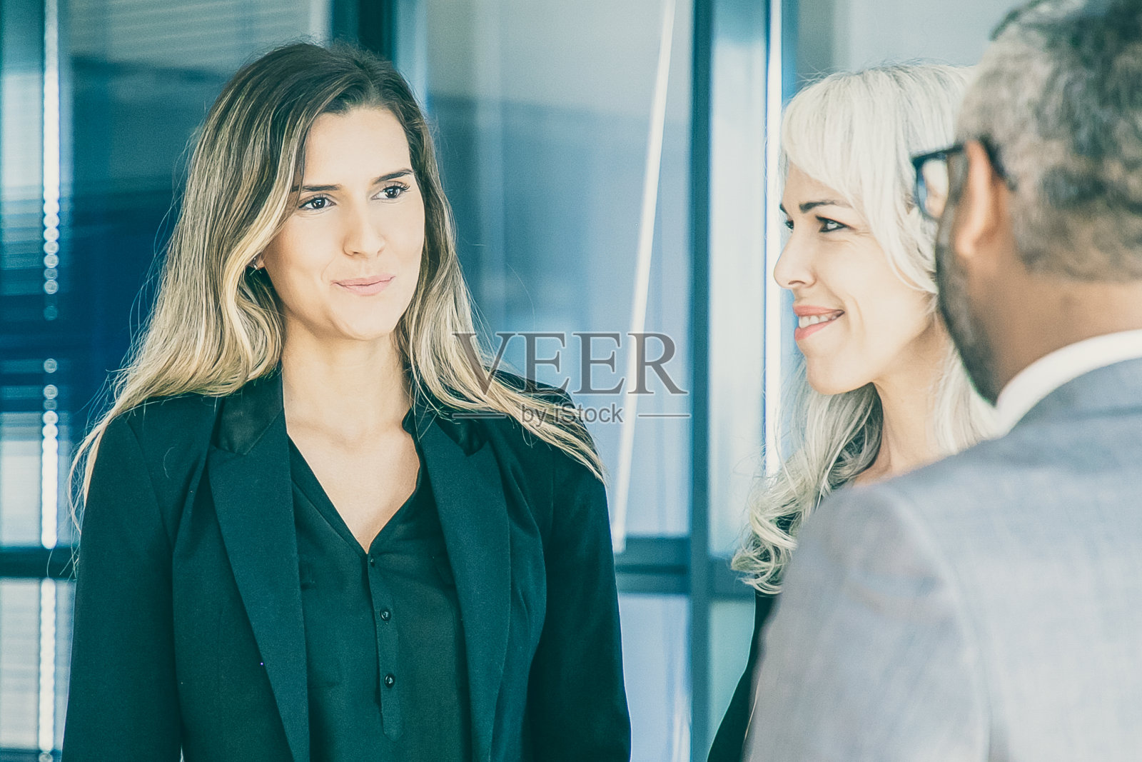 女商人站在办公室里和同事聊天照片摄影图片