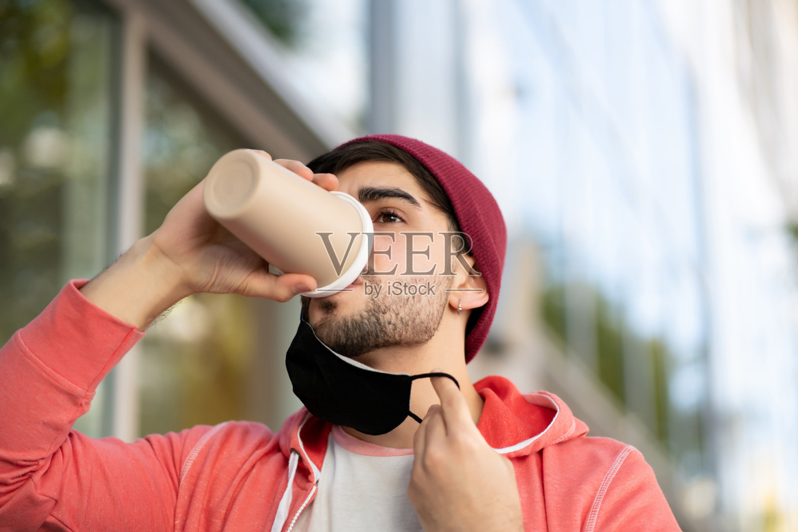 一个年轻人在户外喝咖啡。照片摄影图片