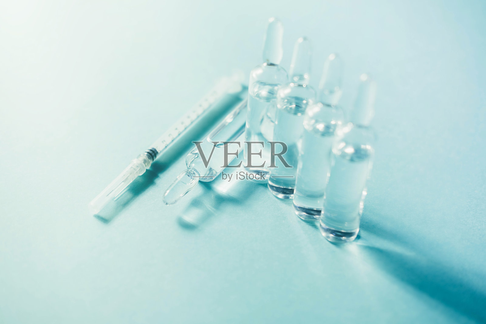 蓝色背景的液体玻璃安瓿。照片摄影图片