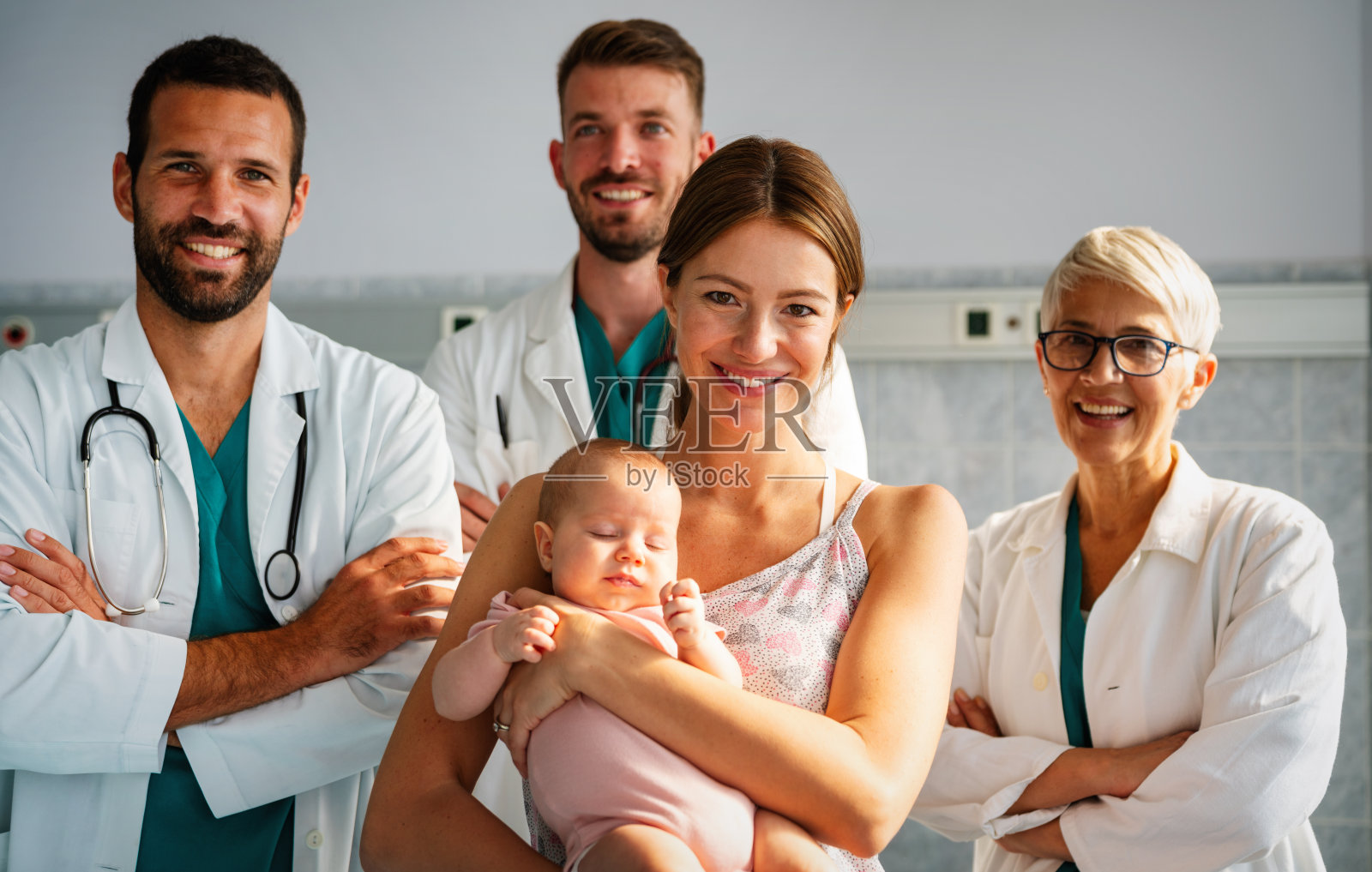 自信的医疗团队与婴儿和父母在医院的肖像照片摄影图片