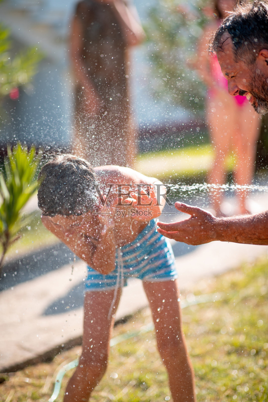 在后院玩水花的家庭照片摄影图片