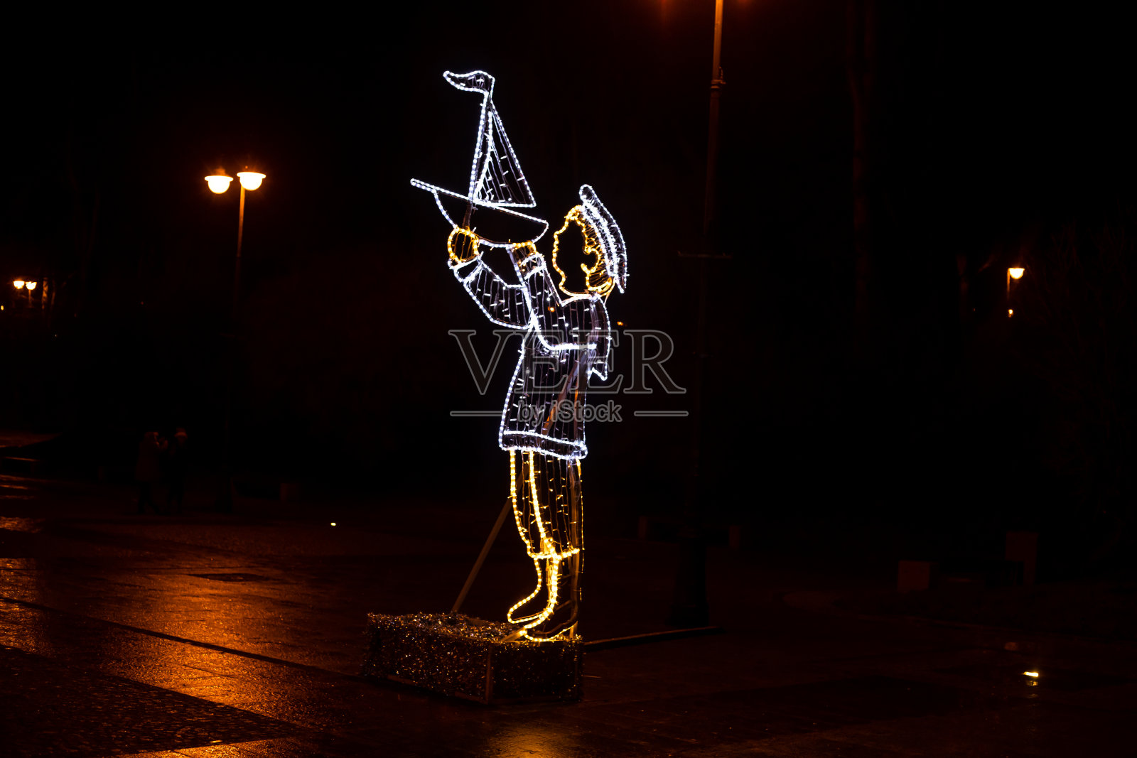 城市灯光装饰在夜晚的城市。抽象的男孩手里拿着船。照片摄影图片