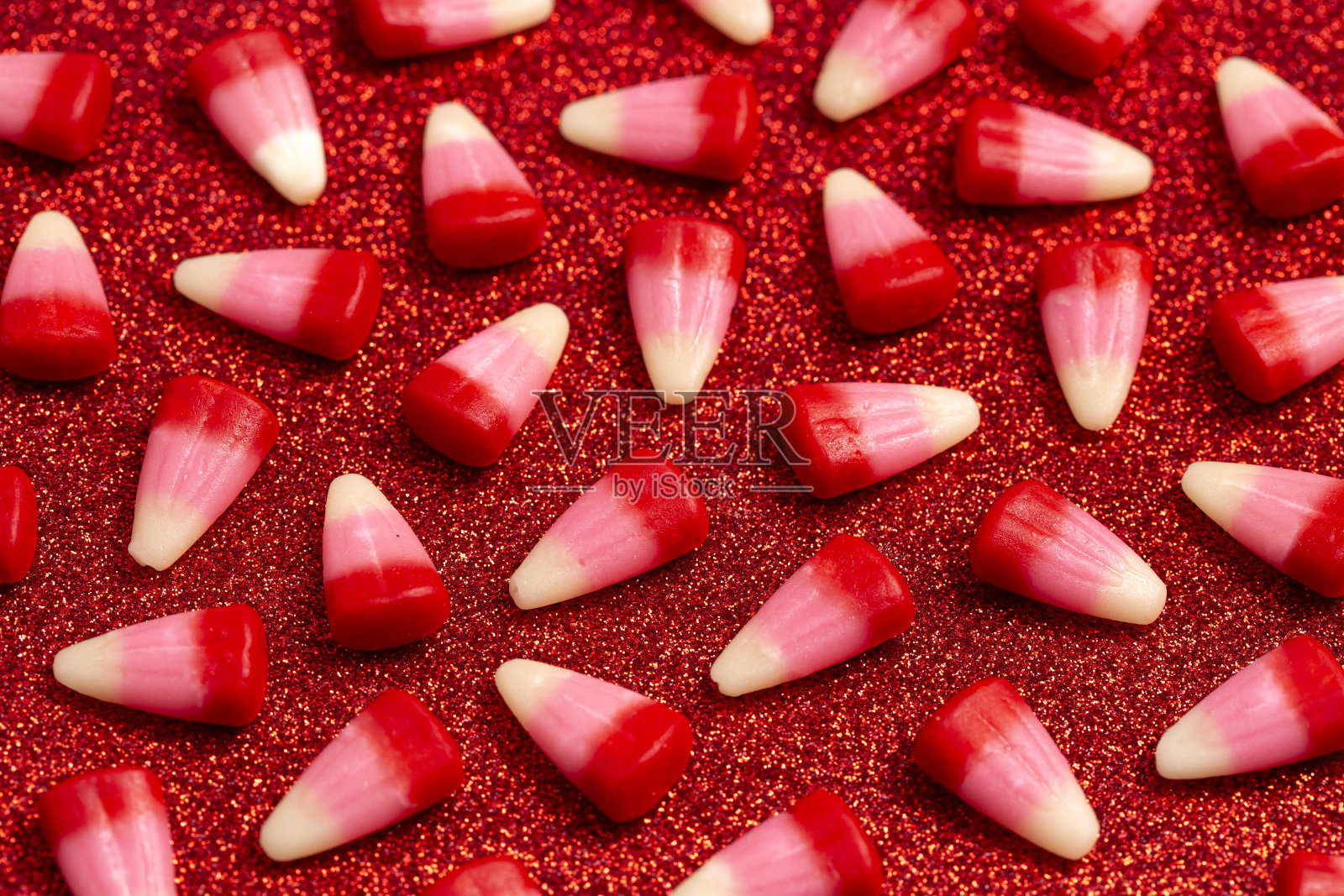 红粉白情人节糖果玉米在闪闪发光的红色背景照片摄影图片