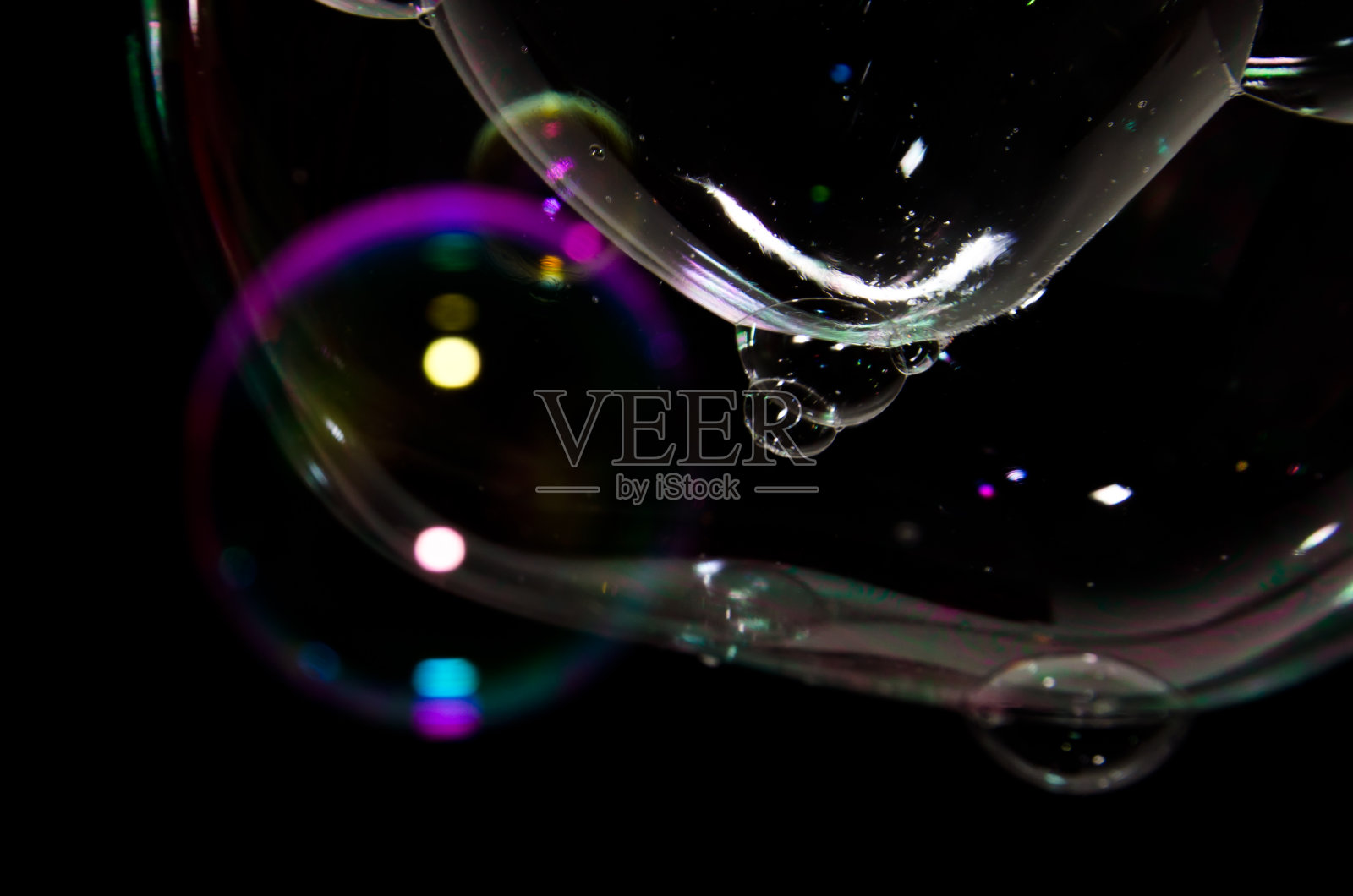 美丽的肥皂泡在黑色背景前，明亮而有光泽照片摄影图片