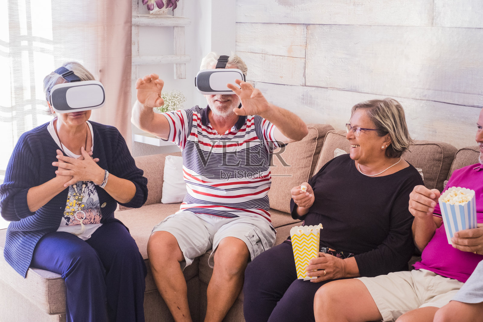 快乐的一群资深朋友一起使用眼镜耳机和享受技术-老白种人享受现代在线游戏和连接在一起庆祝照片摄影图片