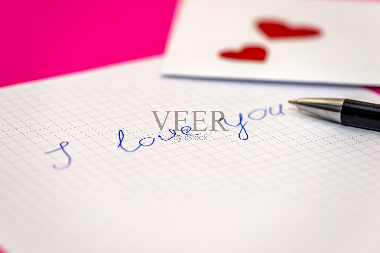 情书，钢笔和信封，粉红色背景上的小心形纸照片摄影图片