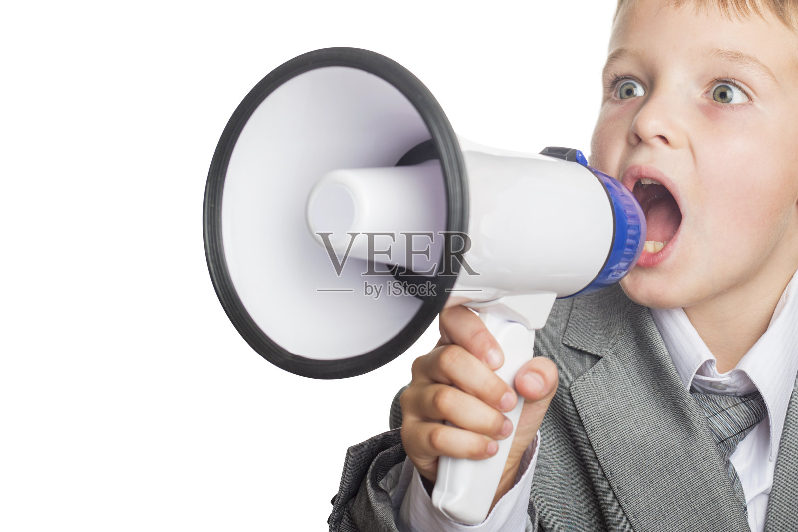 孩子商人拿着扩音器。一个小男孩通过扩音器大喊大叫的肖像。孩子对着扩音器尖叫。照片摄影图片