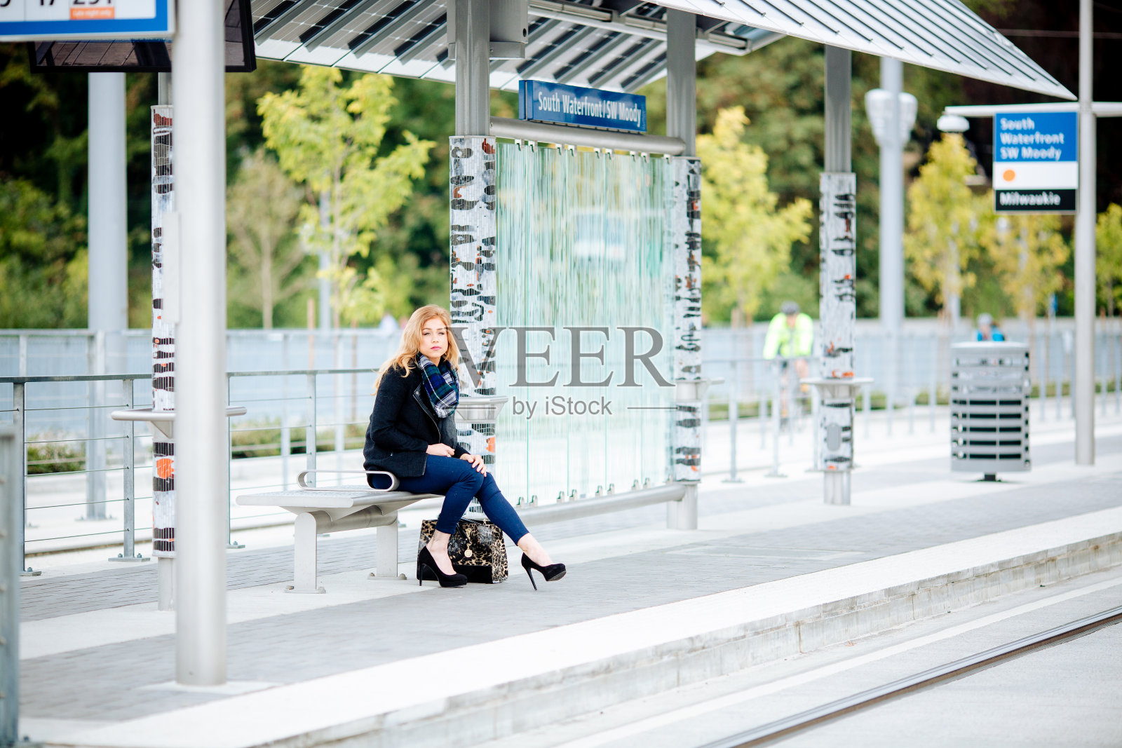 在繁忙的城市里等公共汽车的女人照片摄影图片