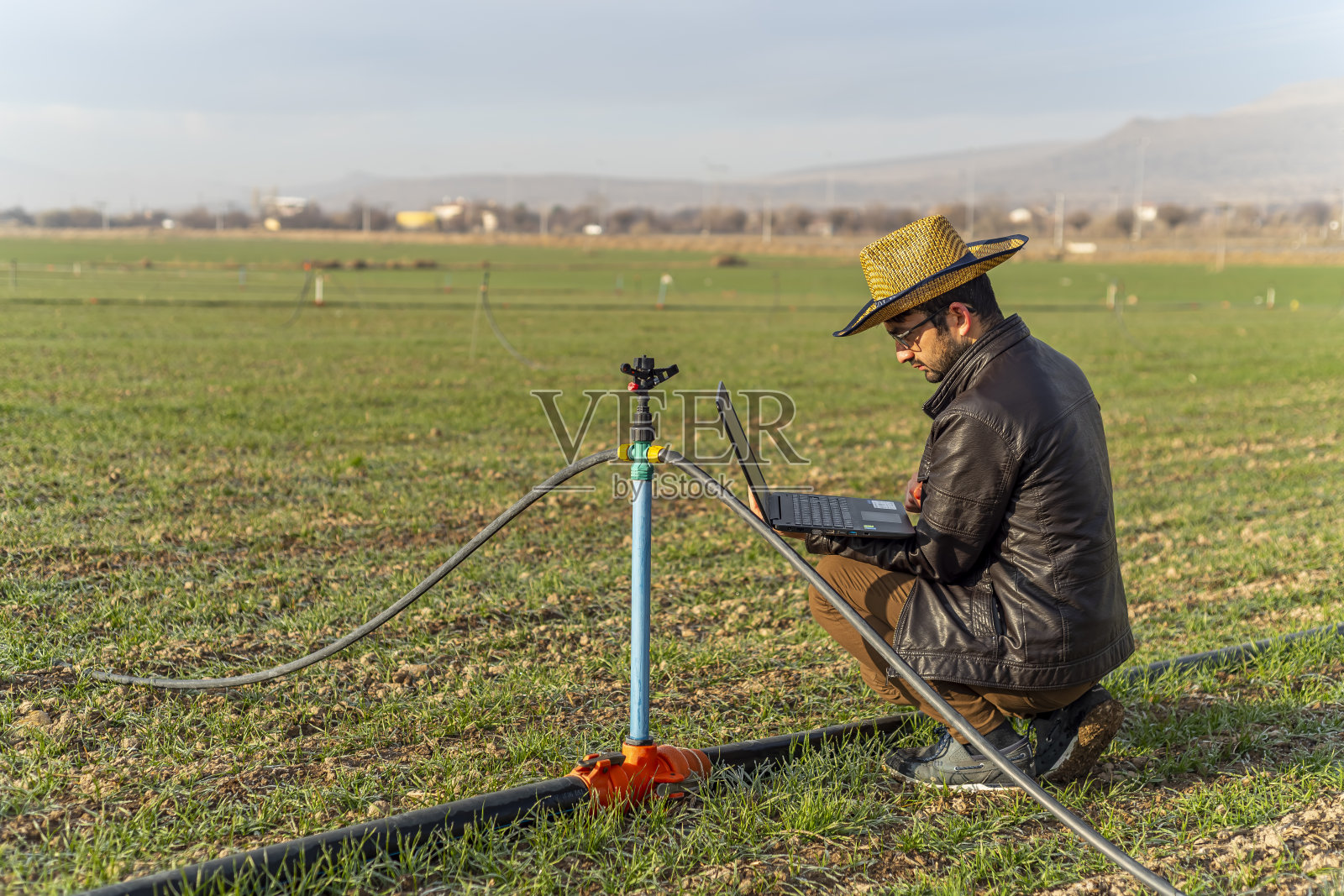 智慧农业理念。在模糊的有机农场上，手持平板电脑的男子作为背景。照片摄影图片