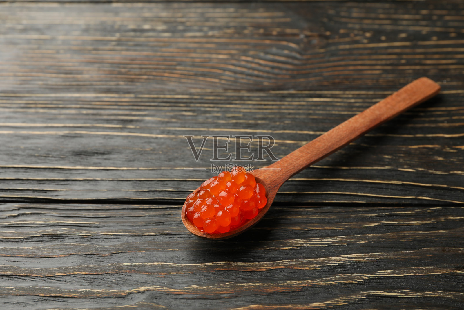 勺子与红色鱼子酱木制背景，文字空间照片摄影图片
