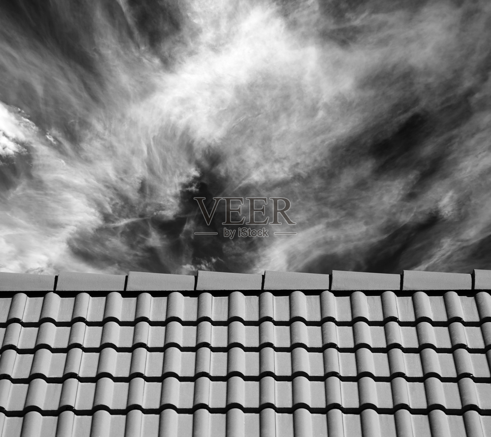 在阳光明媚的日子里，屋顶上的瓦片和天空上的云朵照片摄影图片