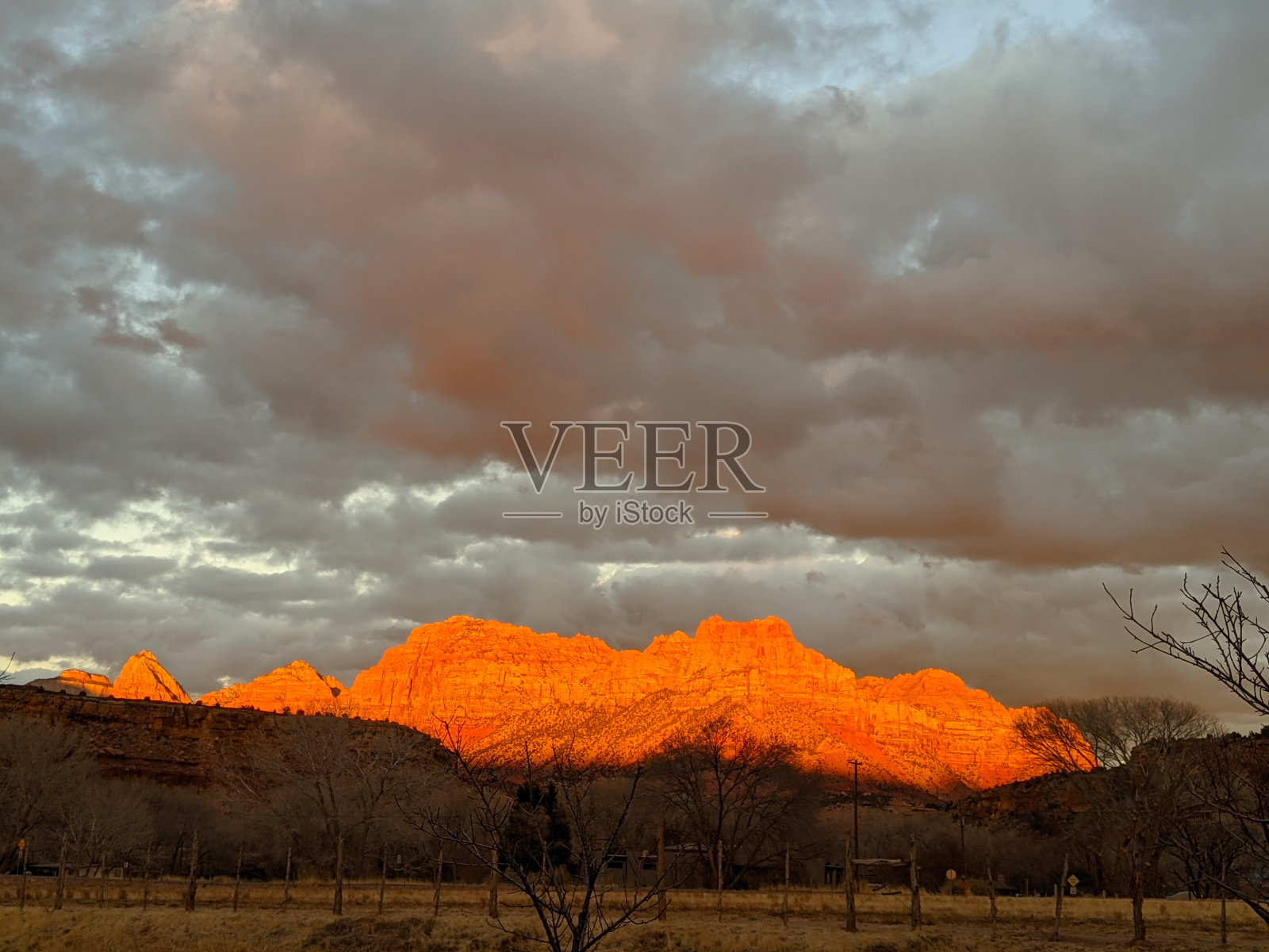 日落的辉光在锡安国家公园的山峰和云景从洛克维尔犹他州在冬季牧场照片摄影图片