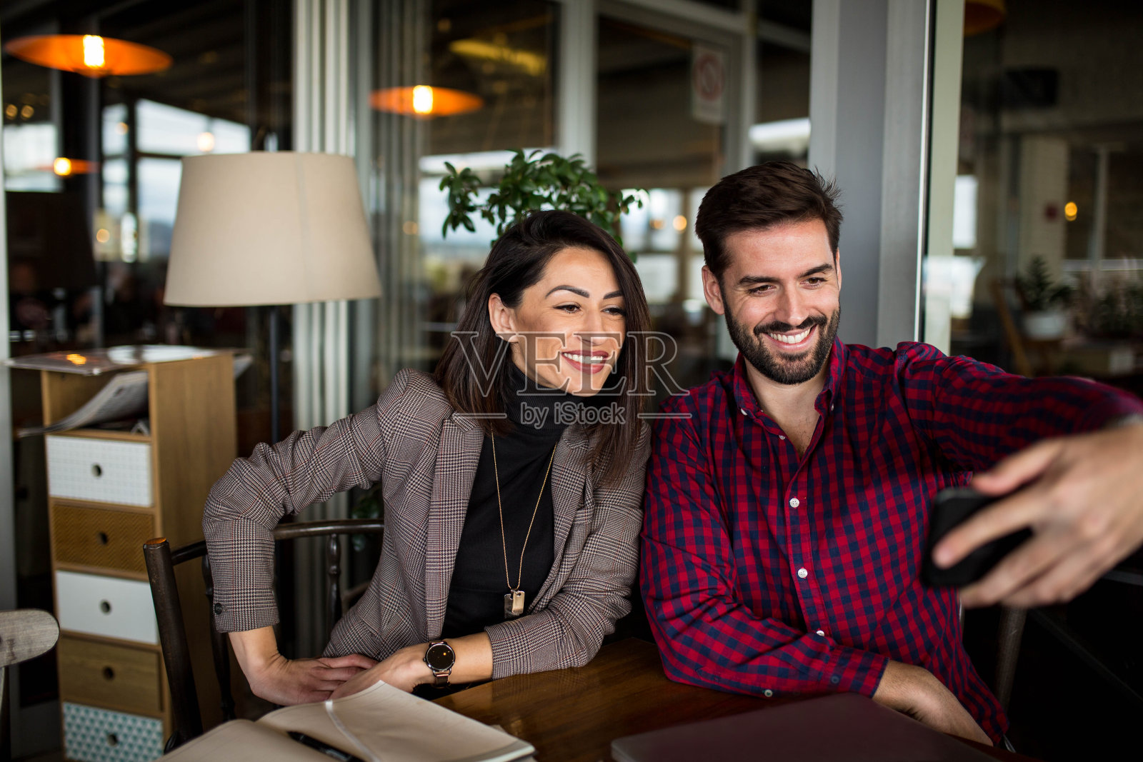 在一次成功的商务会议后，同事们在电话中自拍照片摄影图片