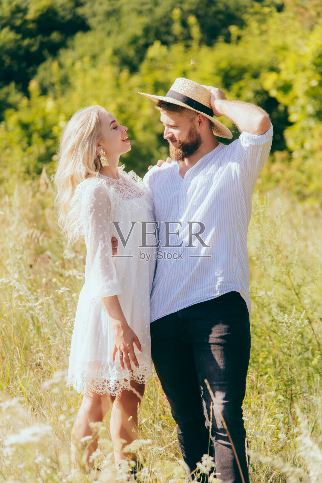 快乐的乡下男子头戴帽子与心爱的女友在阳光明媚的夏日里合影照片摄影图片
