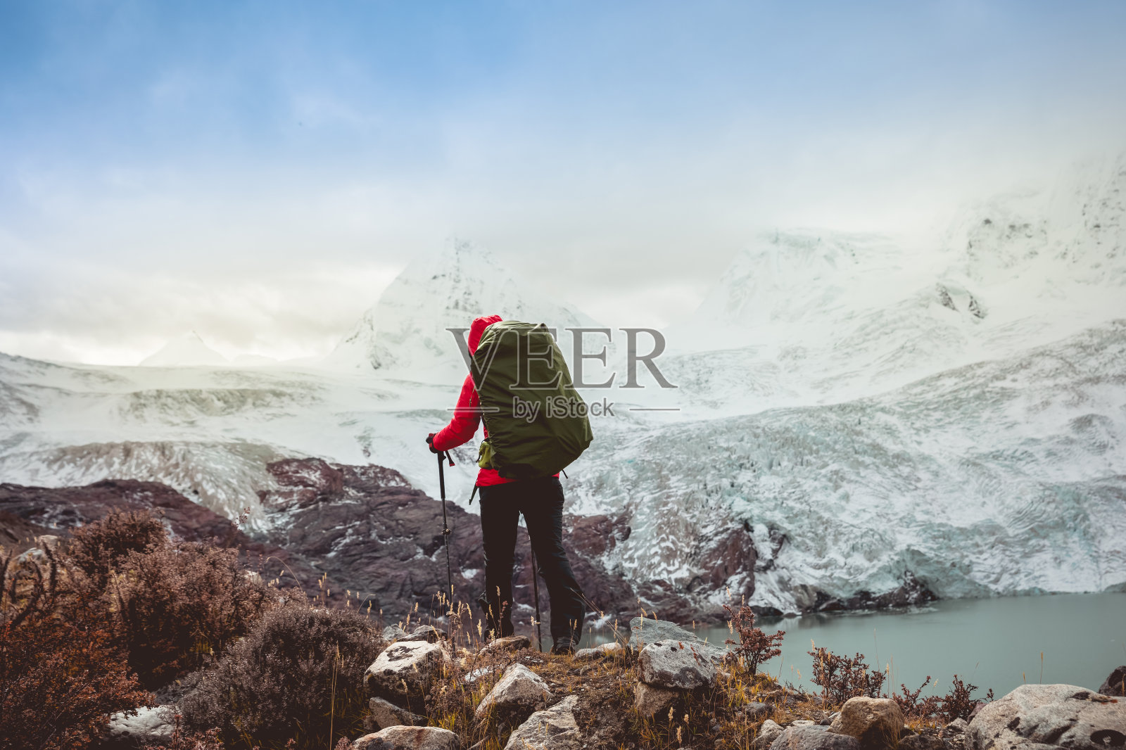成功的女性背包客在冬季的山上徒步旅行照片摄影图片