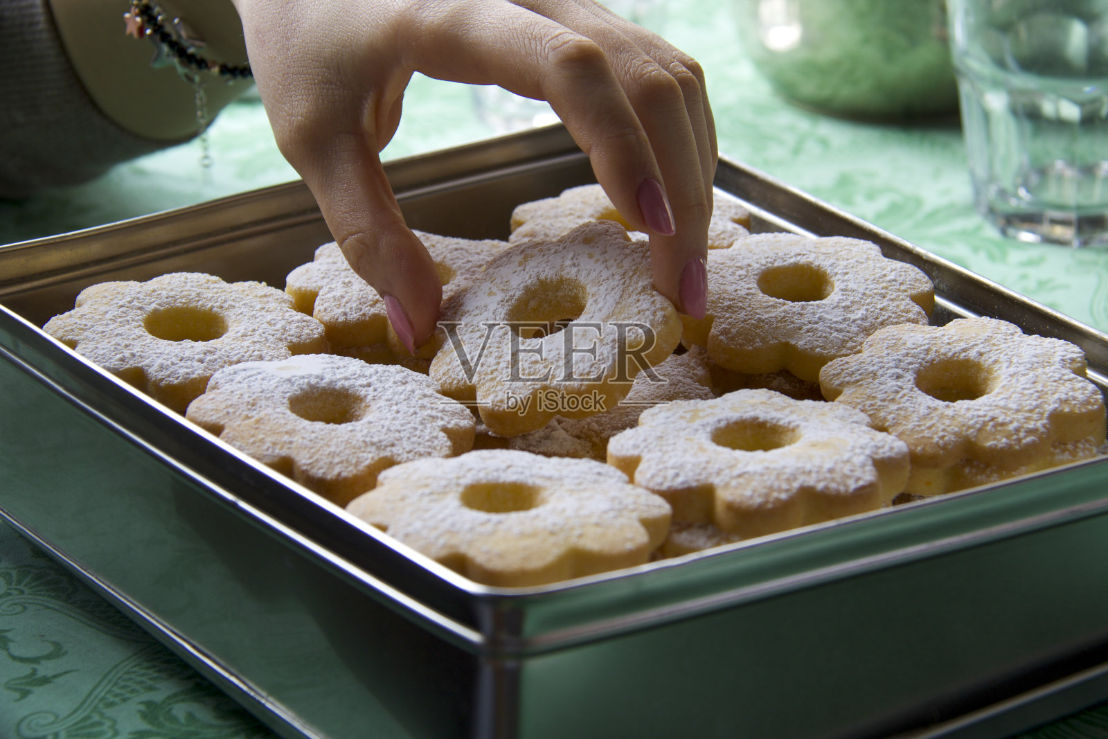 女人的手从盒子里拿出一块饼干照片摄影图片