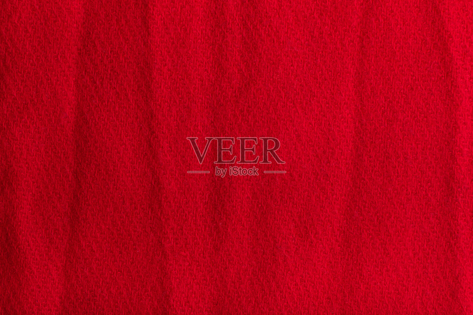 红色羊毛织物的纹理背景。皱巴巴的表面照片摄影图片