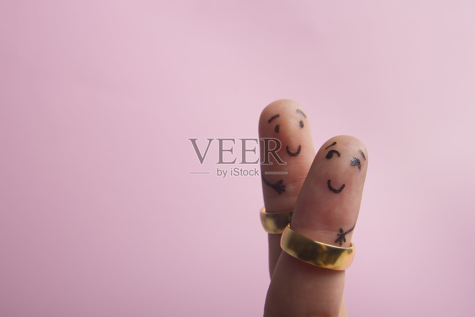 画幸福的手指微笑在粉红色的背景与广告文本复制空间。婚姻的结婚戒指照片摄影图片