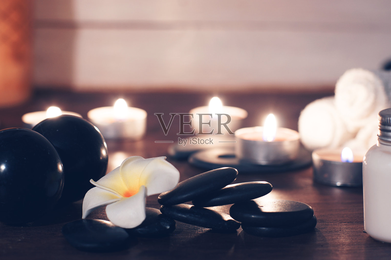 平黑热按摩石，并在桌上留下鸡蛋花与水疗集照片摄影图片