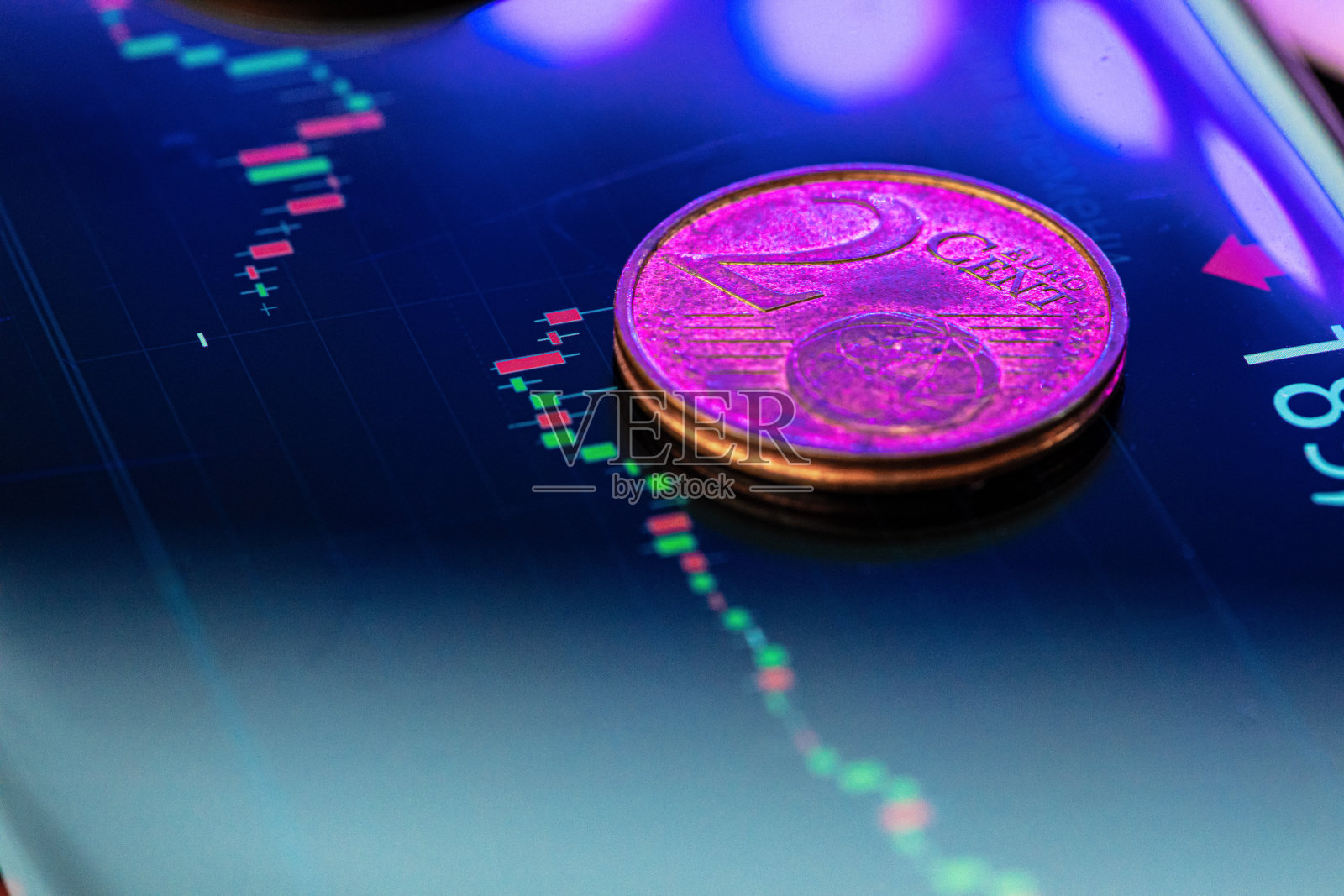 欧元硬币在股票图表上。金融投资的概念。照片摄影图片