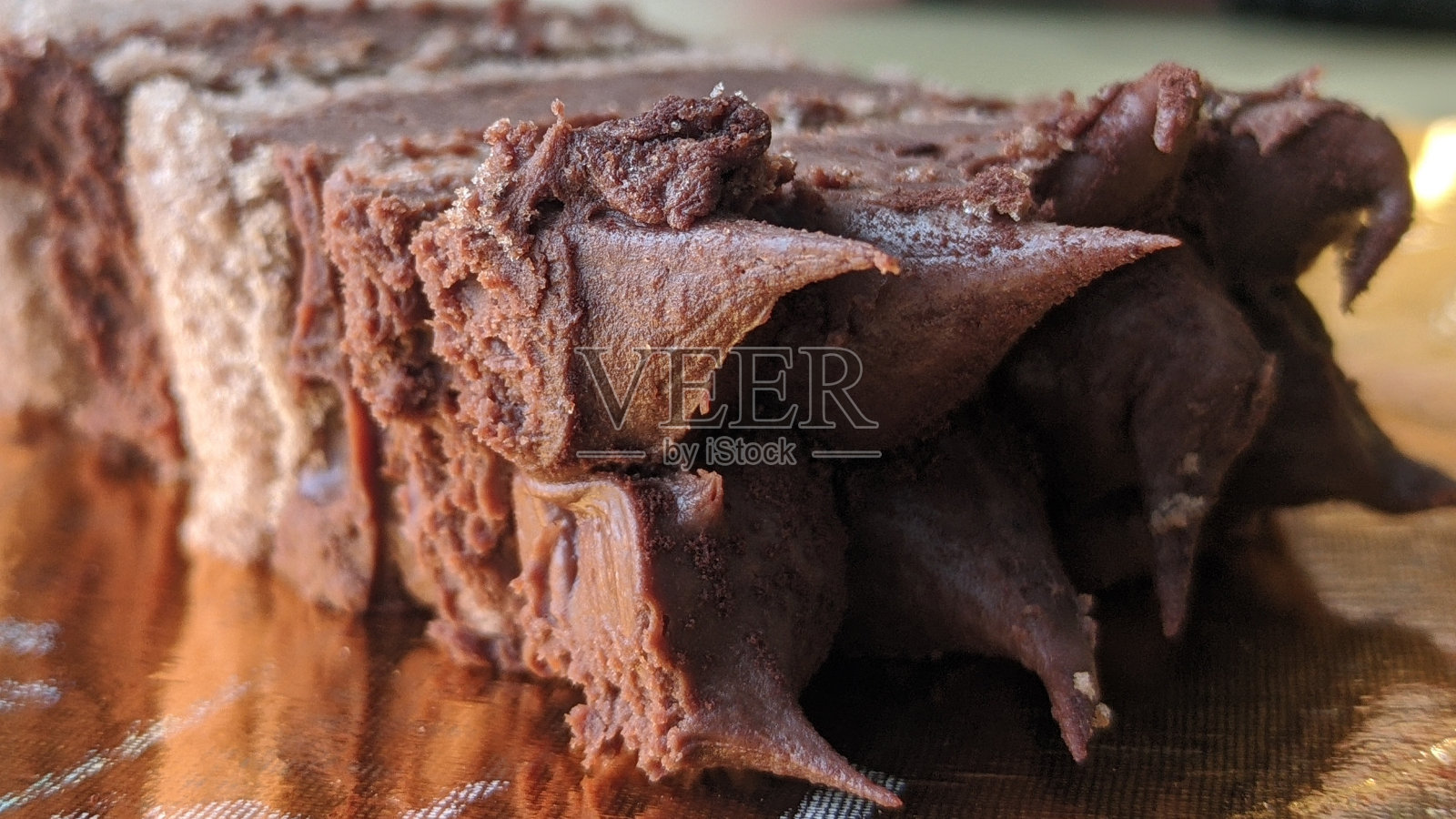 1片中间有奶油的巧克力蛋糕，金盘照片摄影图片