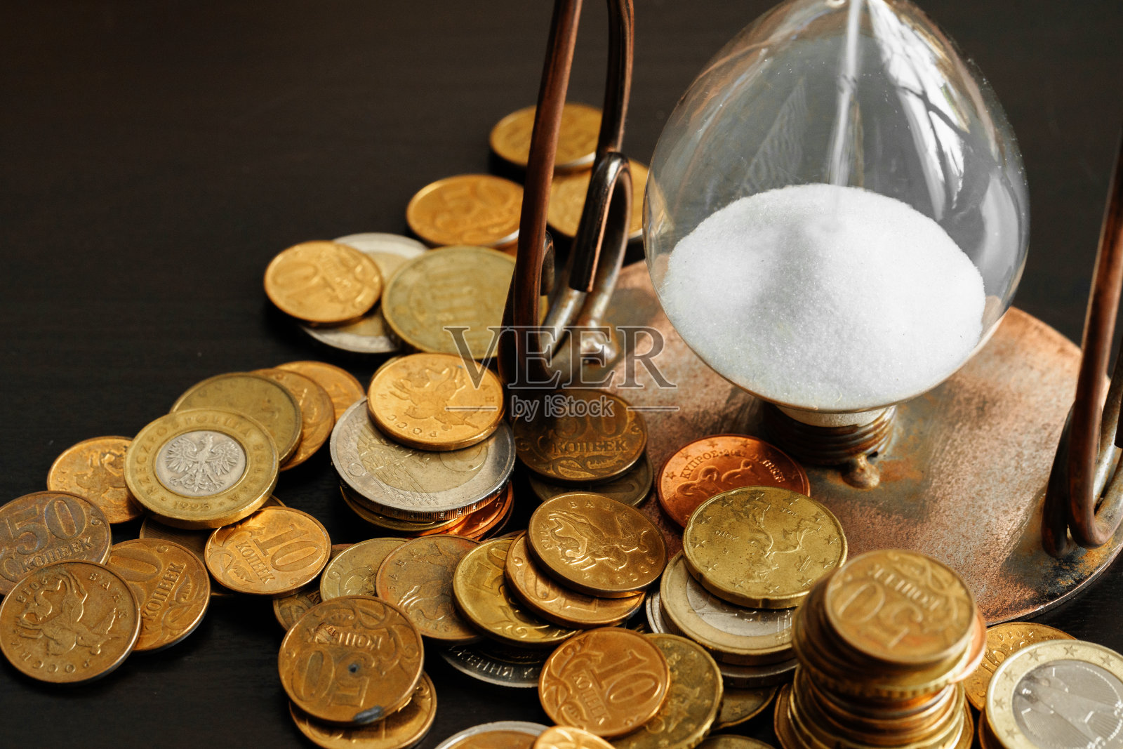 时间就是金钱。近距离的沙漏与钱硬币照片摄影图片