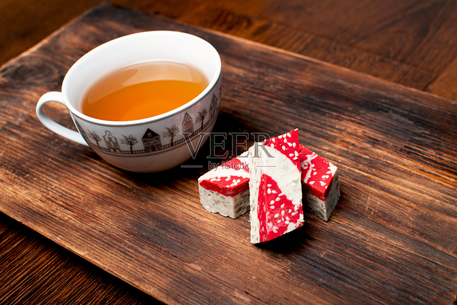 石榴半片甜品配上一杯茶放在木桌上。照片摄影图片