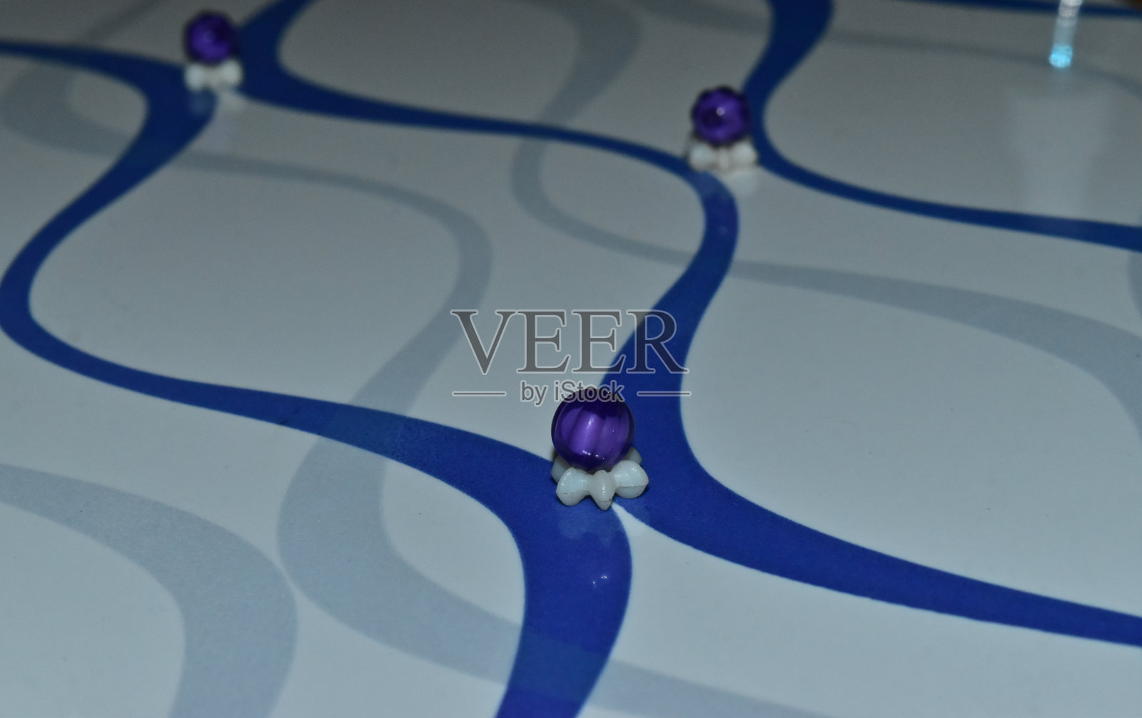 瓷砖表面有紫色和白色的塑料物体照片摄影图片