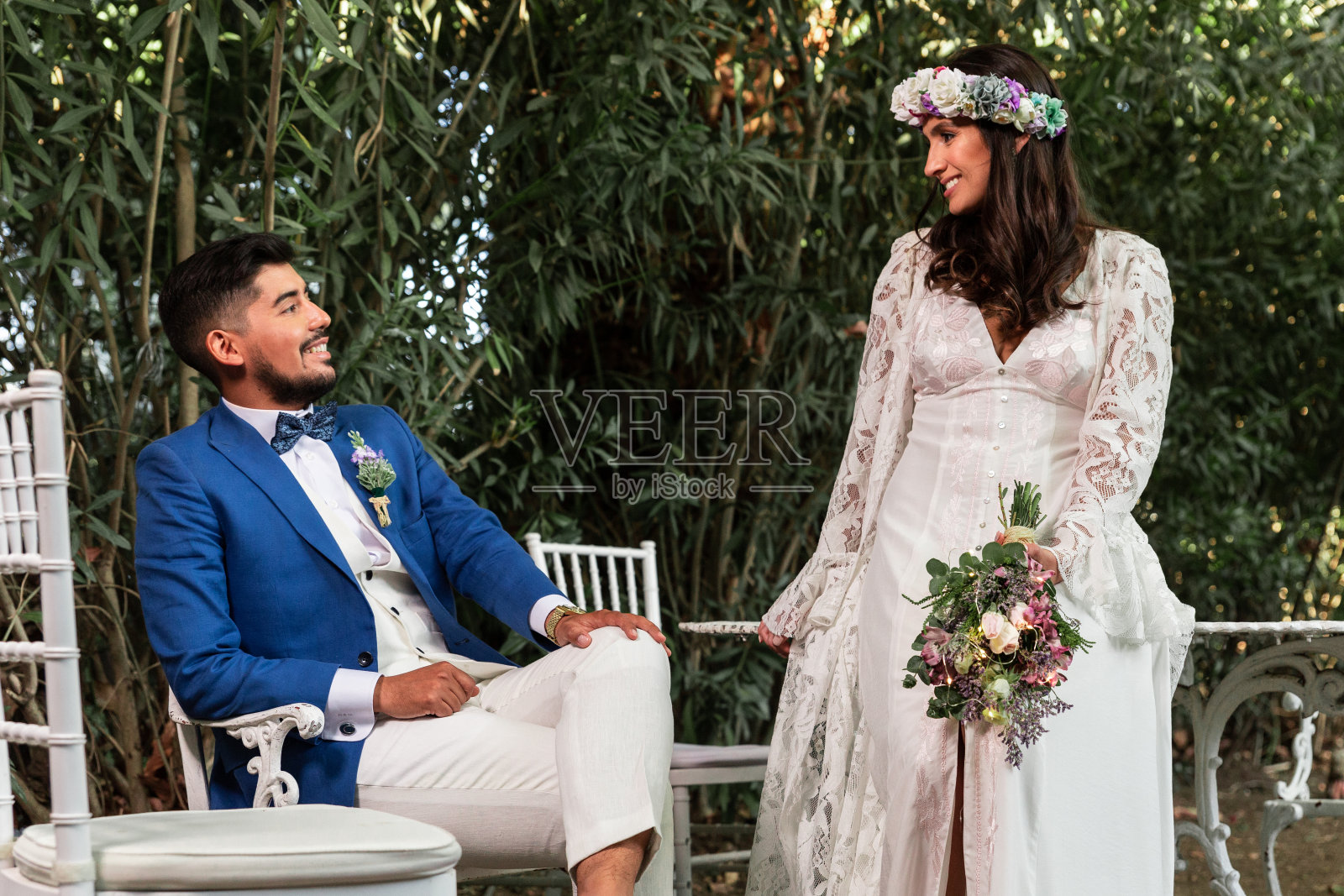 幸福和漂亮的新婚夫妇摆姿势坐。照片摄影图片