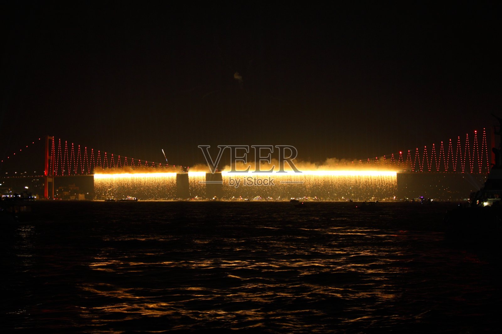 土耳其共和国日庆祝活动期间，伊斯坦布尔博斯普鲁斯海峡上空燃放烟花。博斯普鲁斯大桥，夜间有红色的灯光和激光。照片摄影图片