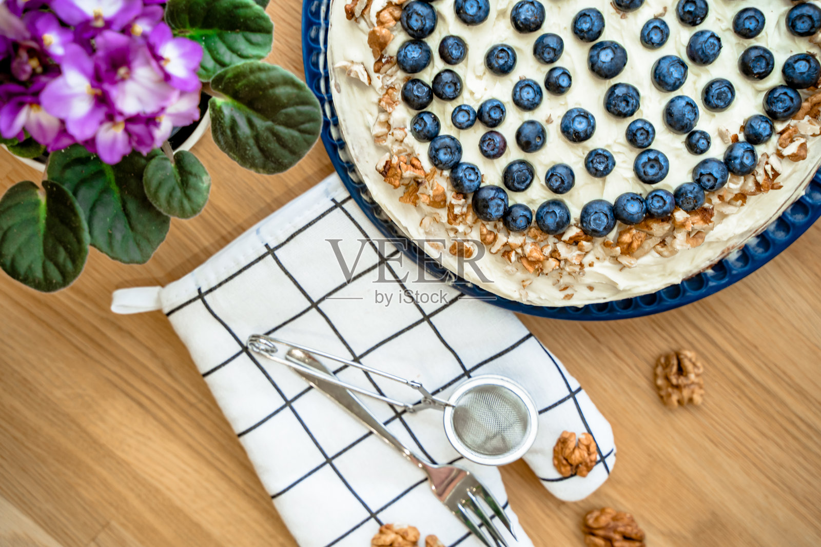 用蓝莓装饰的白干酪自制胡萝卜蛋糕，家居装饰，靠窗的木桌照片摄影图片