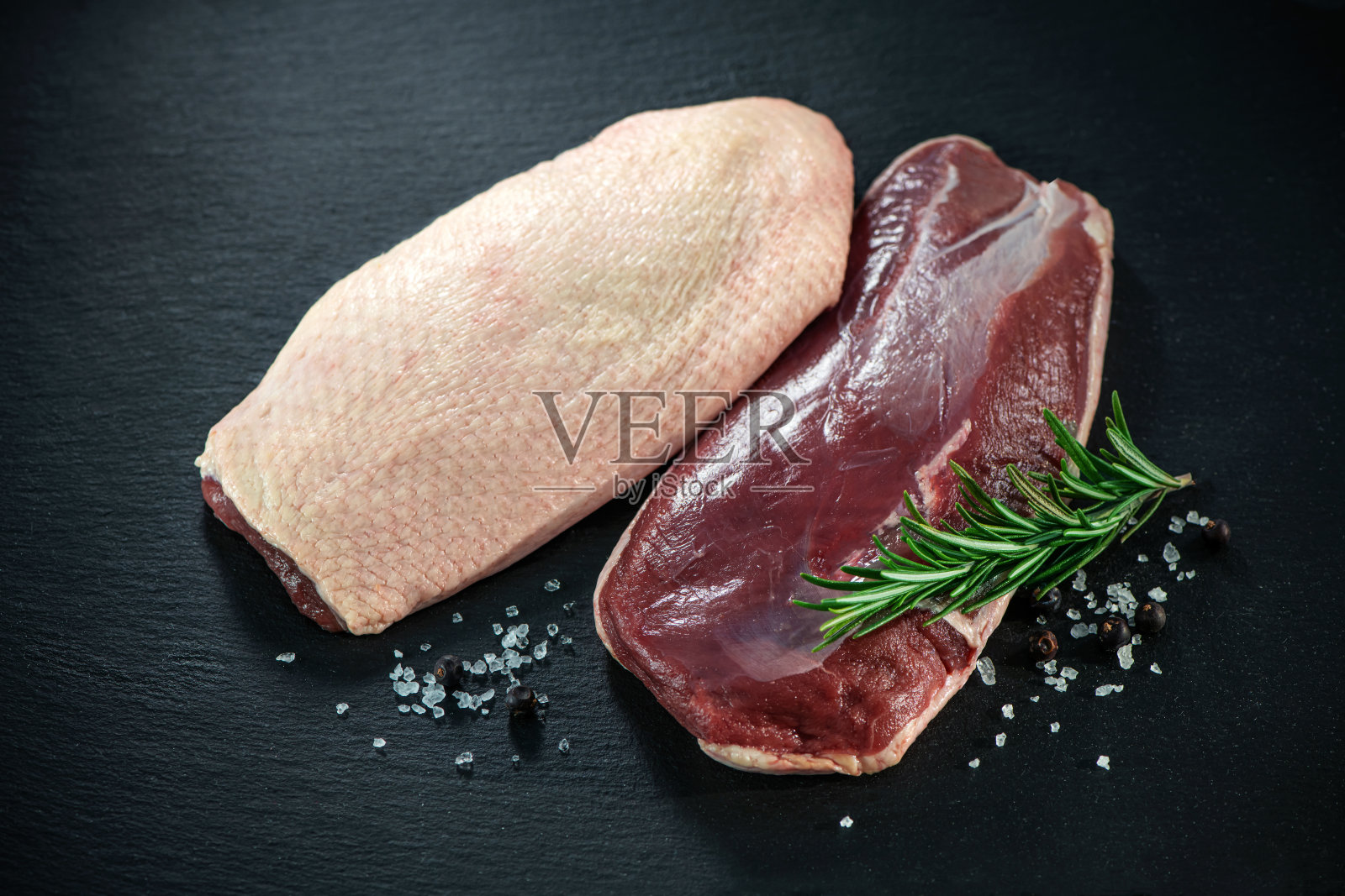 生鸭胸片在深色石板背景上照片摄影图片