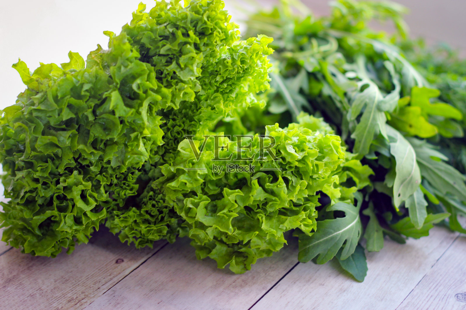 绿色的莳萝叶和芝麻菜在木制的背景上照片摄影图片