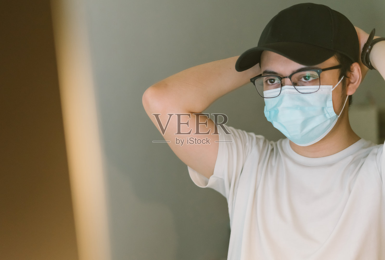 亚洲年轻人在办公室工作，戴着口罩预防COVID-19照片摄影图片