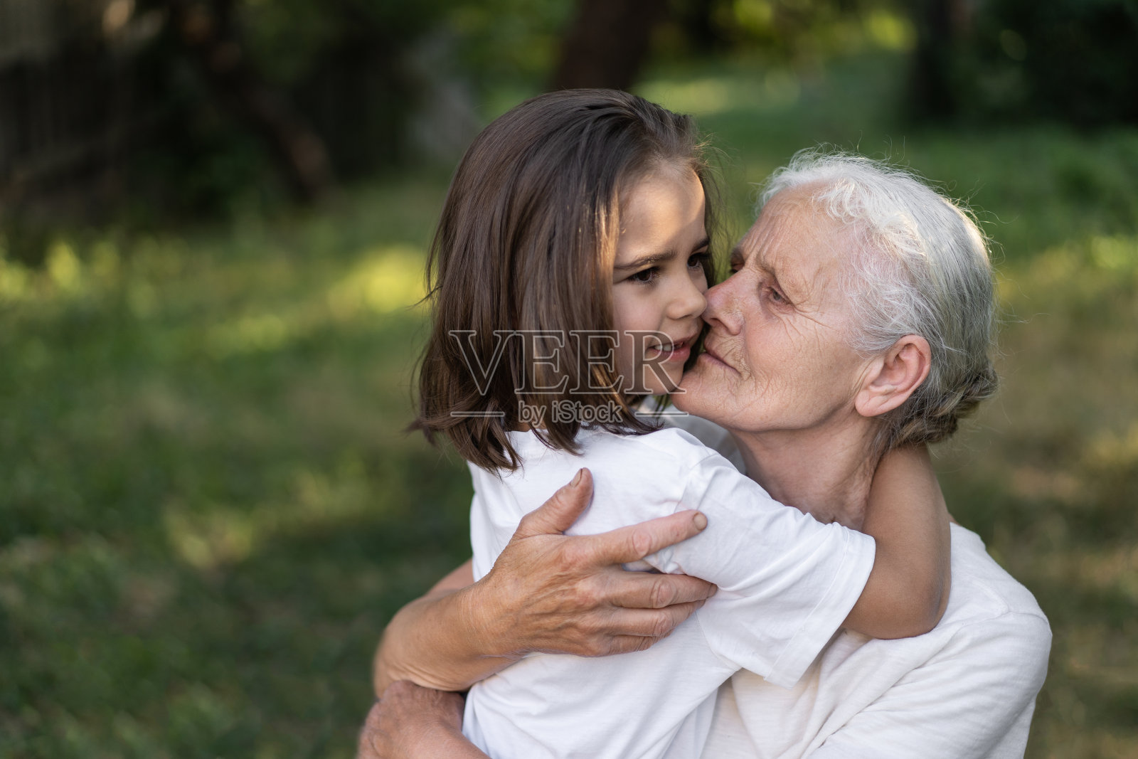 慈祥的孙女和奶奶拥抱在一起。照片摄影图片