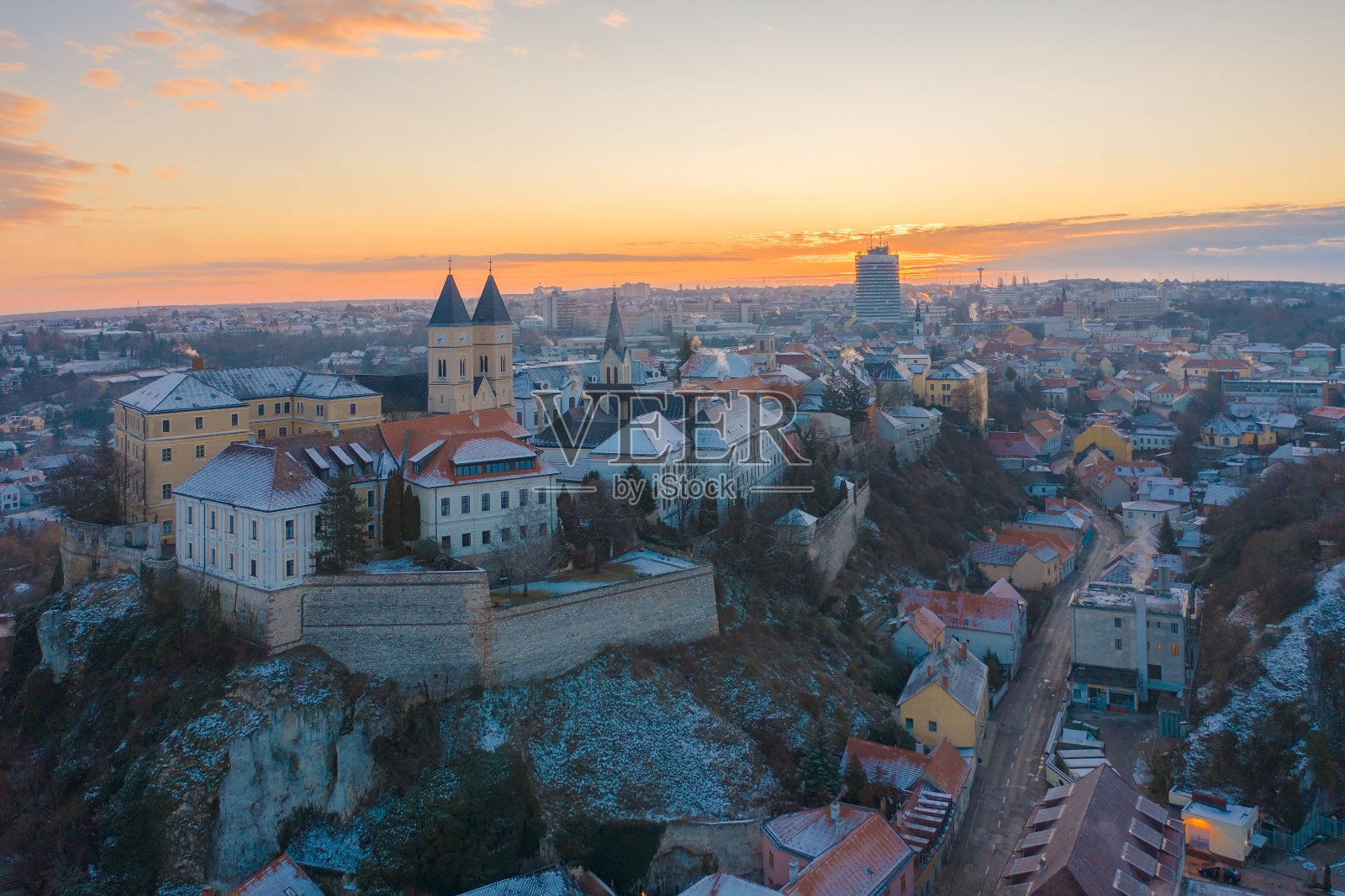 Veszprém，匈牙利- - -在一个冬天的早晨，在一片金色的日出中，Veszprém市中心和城堡区的空中鸟瞰图令人惊叹。历史老建筑。照片摄影图片